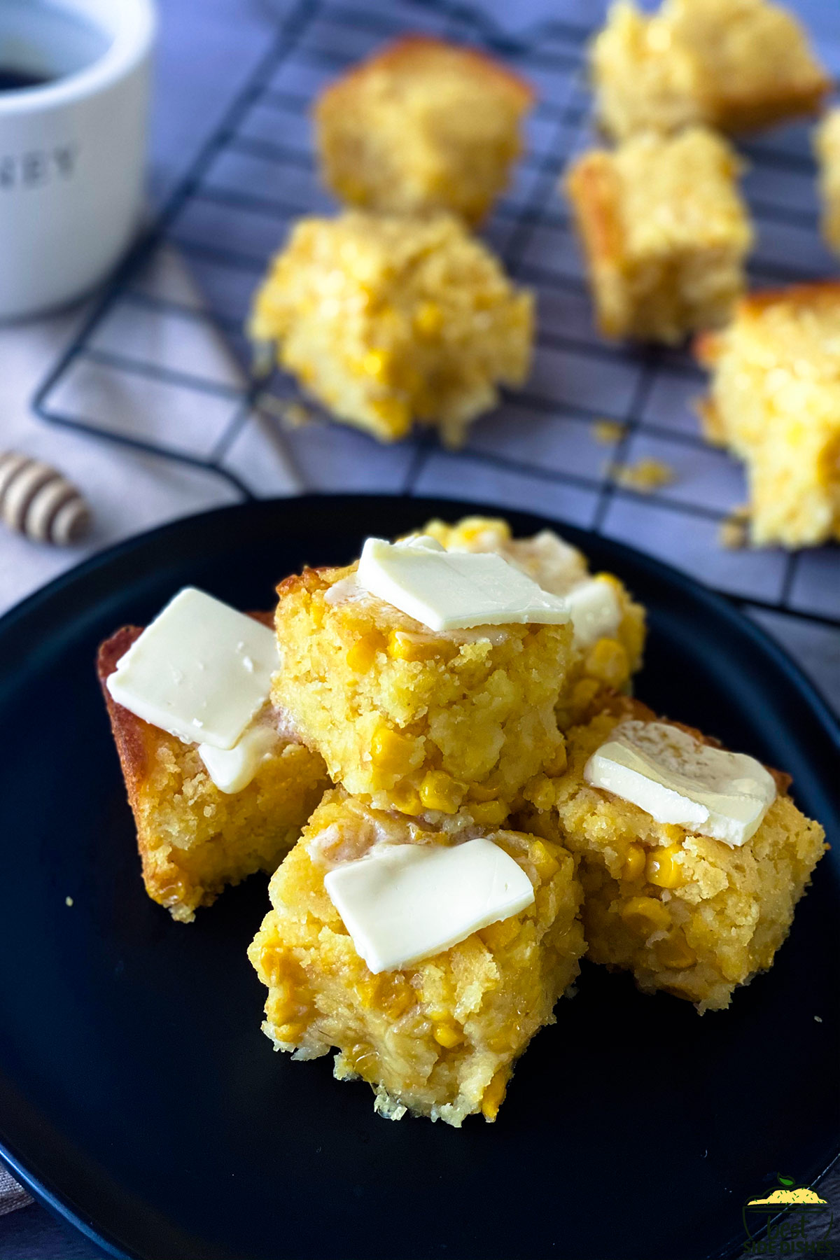 Slices of creamed corn casserole with pats of butter on top