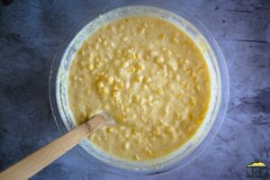 Mixing creamed corn casserole in a bowl