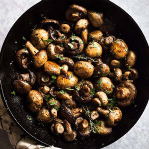 Button mushrooms in a cast iron skillet