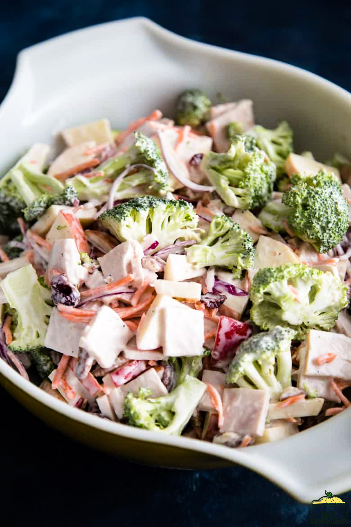 Broccoli salad with apples in a white mixing bowl