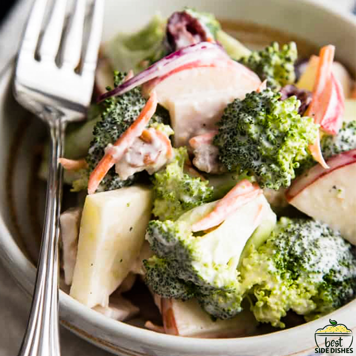 Broccoli apple salad in a bowl with a fork