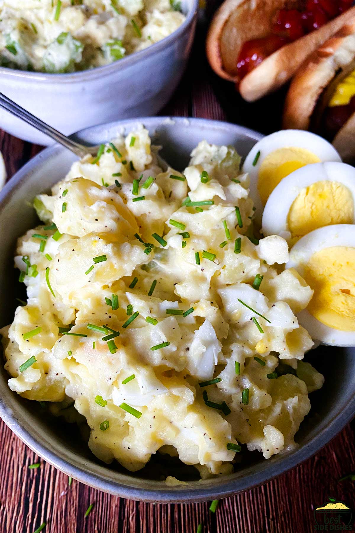 potato salad in a bowl with a fork and egg slices