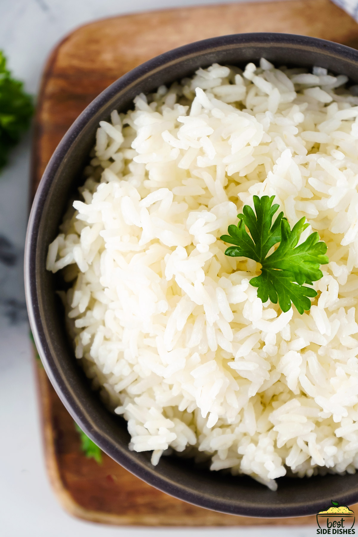 Perfect white rice in a bowl with herbs on top