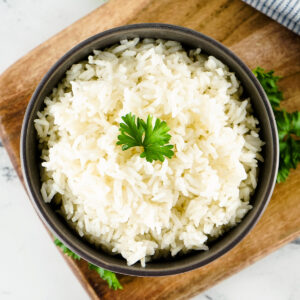 Rice in a bowl with a sprig of herbs on top