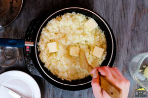 Stirring butter into pan with rice