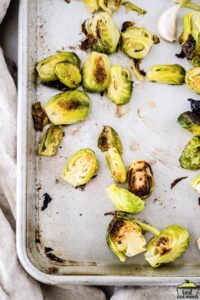 Roasted brussels sprouts and garlic on a baking sheet