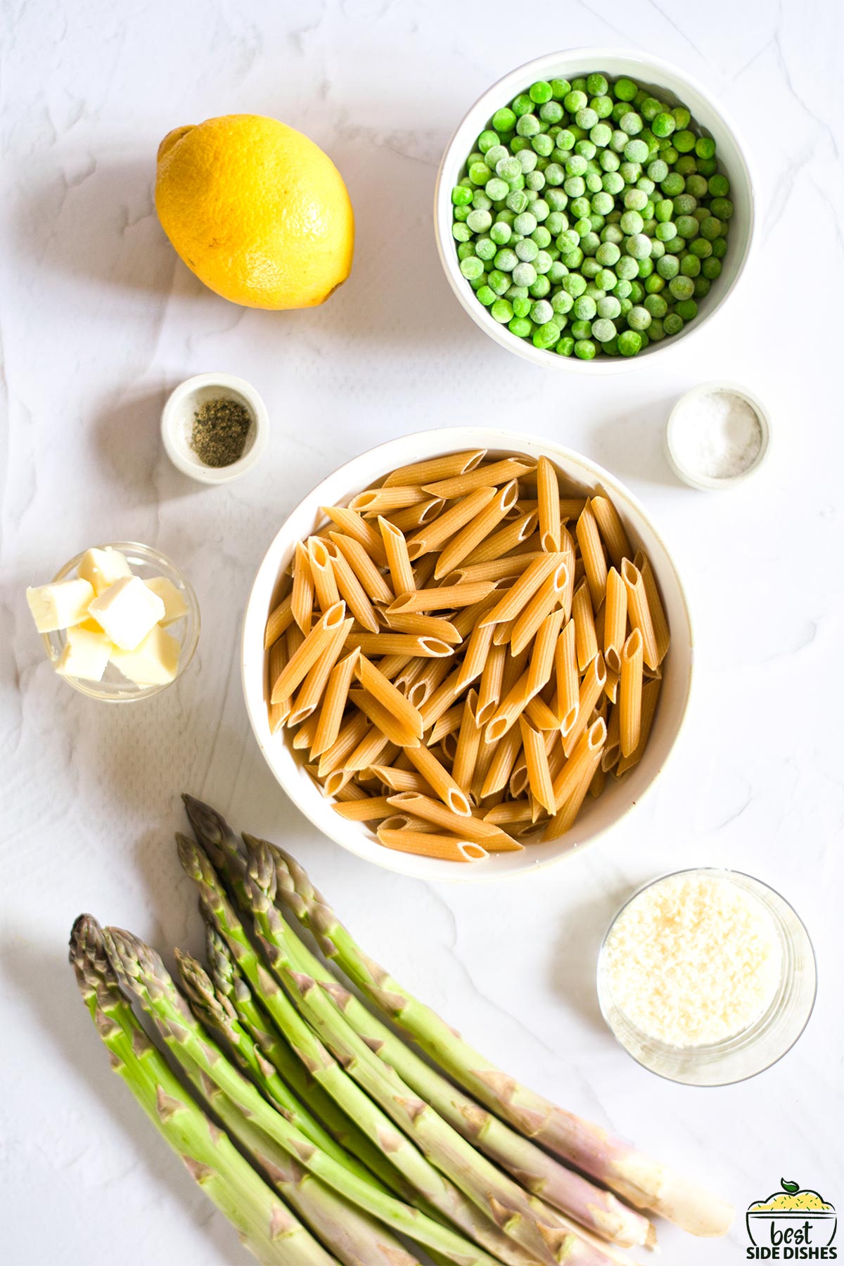 ingredients to make asparagus pasta recipe on white surface