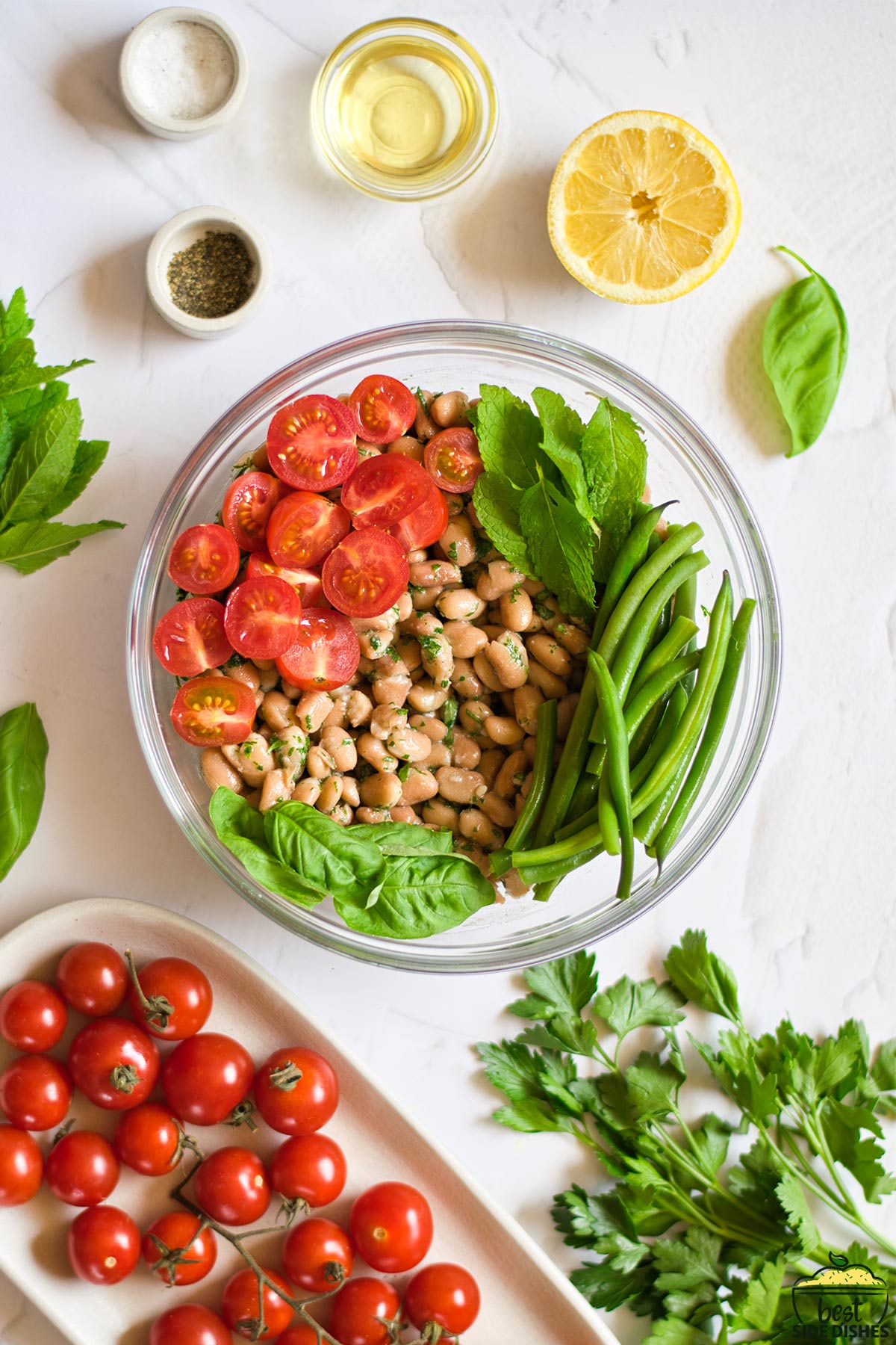 tomatoes, herbs, and beans in a glass bowl