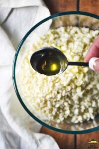 adding olive oil to cauliflower rice