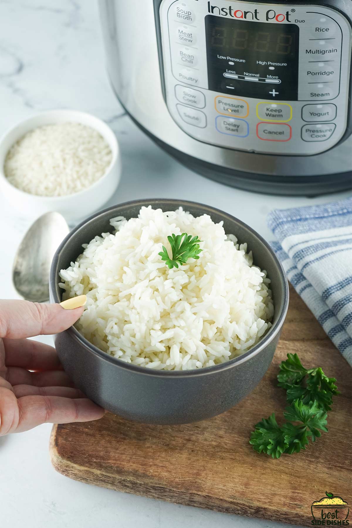 setting down a bowl of instant pot white rice with parsley