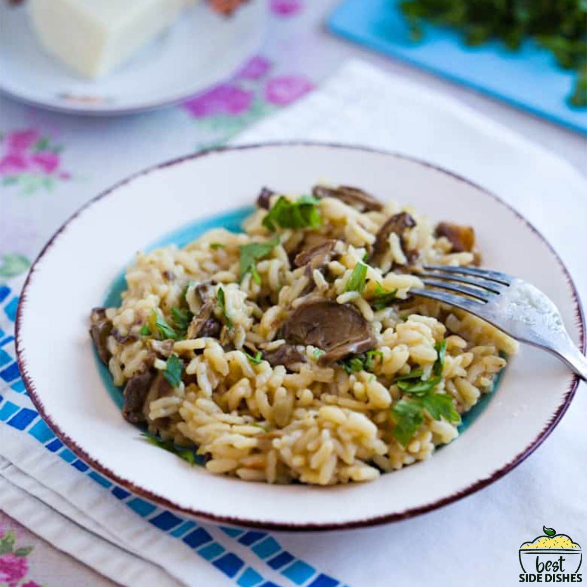 mushroom risotto on a white and teal plate with a fork