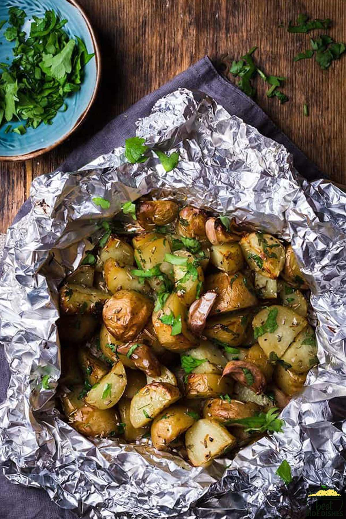 Grilled potatoes in foil with parsley on top