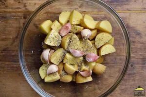 Seasoning potatoes in a bowl
