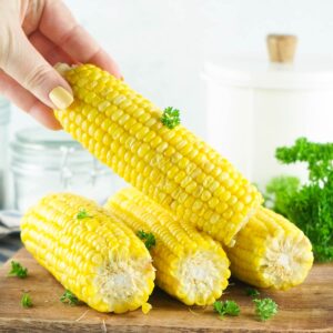 lifting instant pot corn on the cob from wooden board