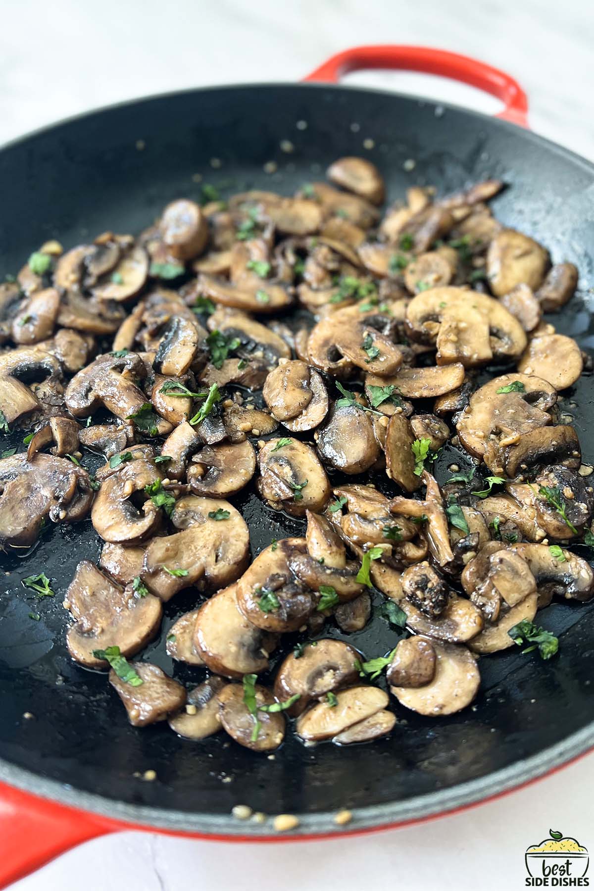 sauteeing mushrooms in a pan with garlic butter